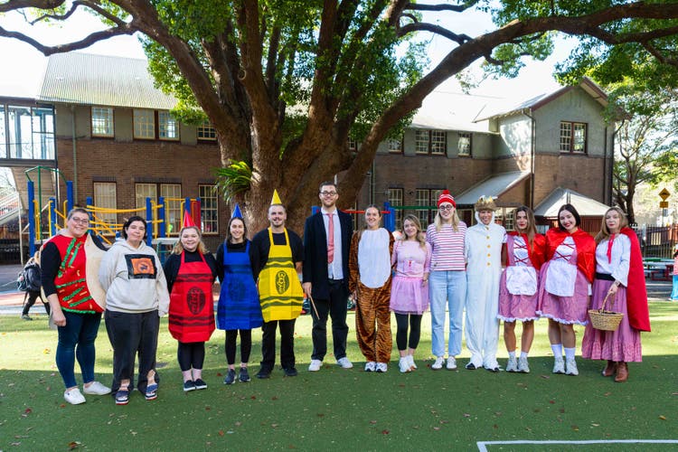 staff standing in the playground dressed up as book characters on the morning of the book parade
